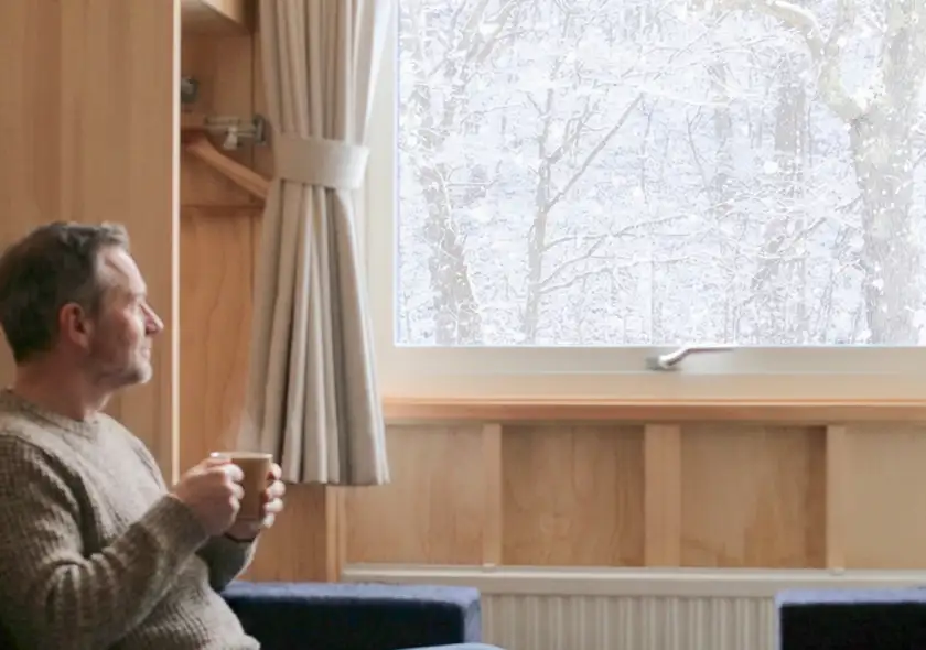 画像:客室から雪景色を見る男性
